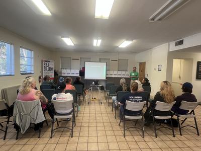 Presenter showing slide "Jones County Crops" to seated audience in meeting room