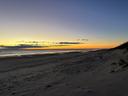 Shoreline at sunrise, Dunes rise to the right of the photo.