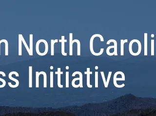 Text "Western North Carolina Small Business Initiative" over layered blue mountain background
