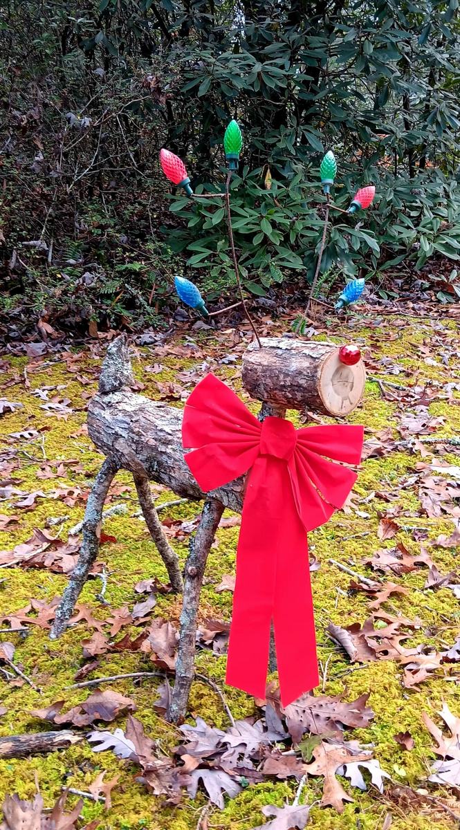 A reindeer lawn decoration made of sticks and logs.