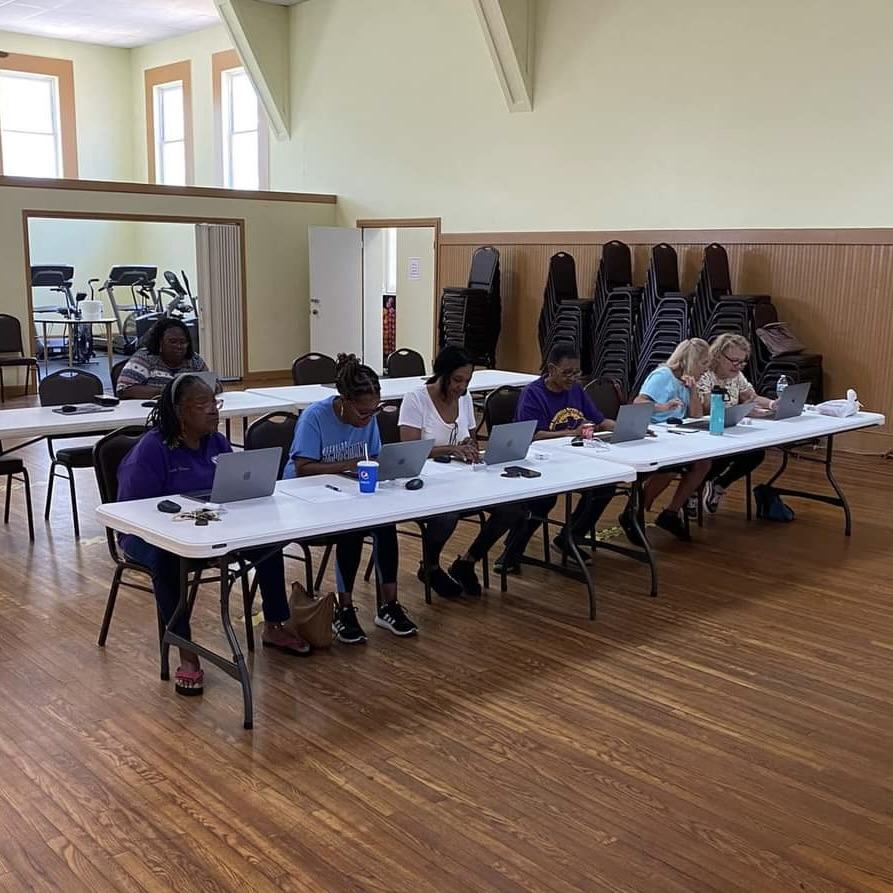 Adults using MacBooks to study digital skills