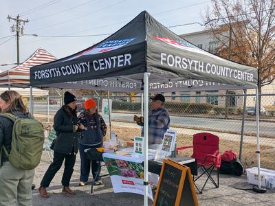 People at farmers market booth talking