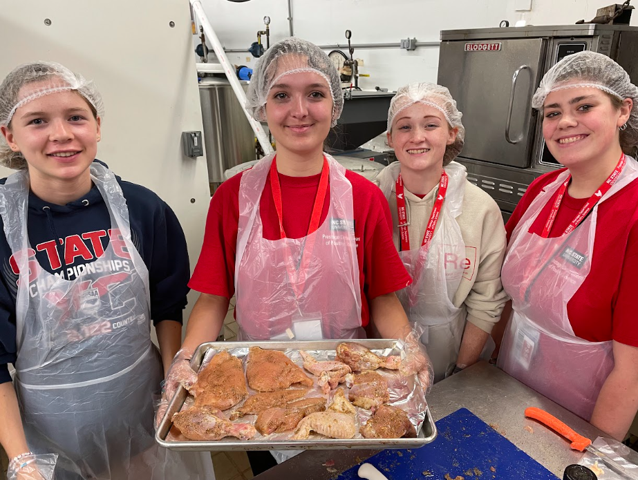 group holding tray of chicken parts