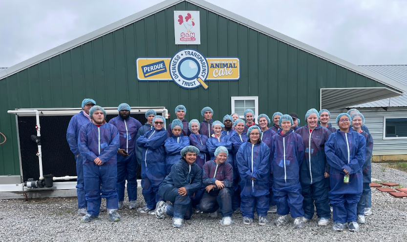 group outside of a broiler farm building
