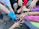 Image of many childrens arms gathered hand-over-hand in a circle
