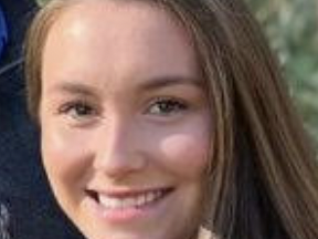 Young woman with long brown hair smiling, close-up portrait