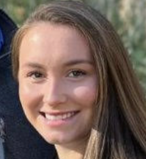 Young woman with long brown hair smiling, close-up portrait