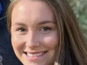 Young woman with long brown hair smiling, close-up portrait
