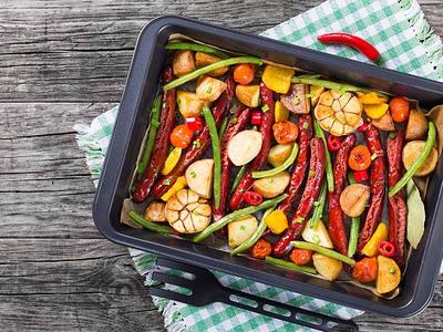 Grilled sausage with garlic, potato, cherry tomatoes, green beans, top-view