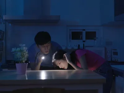 couple with flashlight in dark for hurricane season