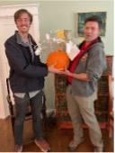 two gentlemen holding a silly pumpkin to promote pumpkin composting