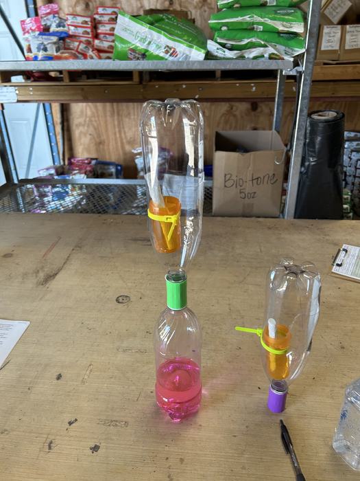 A picture showing two soda bottles connected with a coupling.