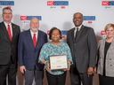 Woman holding framed award labeled NC Cooperative Extension, flanked by four people