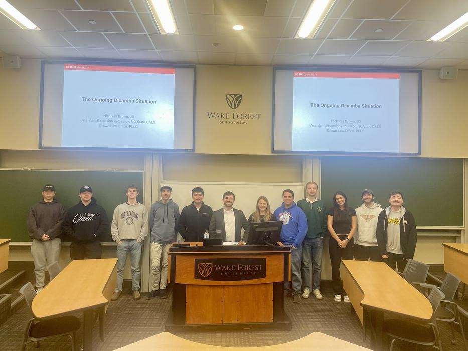 A lecturer poses with students at Wake Forest School of Law.