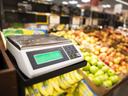 Digital produce scale displaying "0.000" in front of bananas and apples