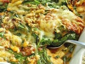 Baked spinach and melted cheese casserole in white dish with serving spoon; 'www.FoodHero.org'