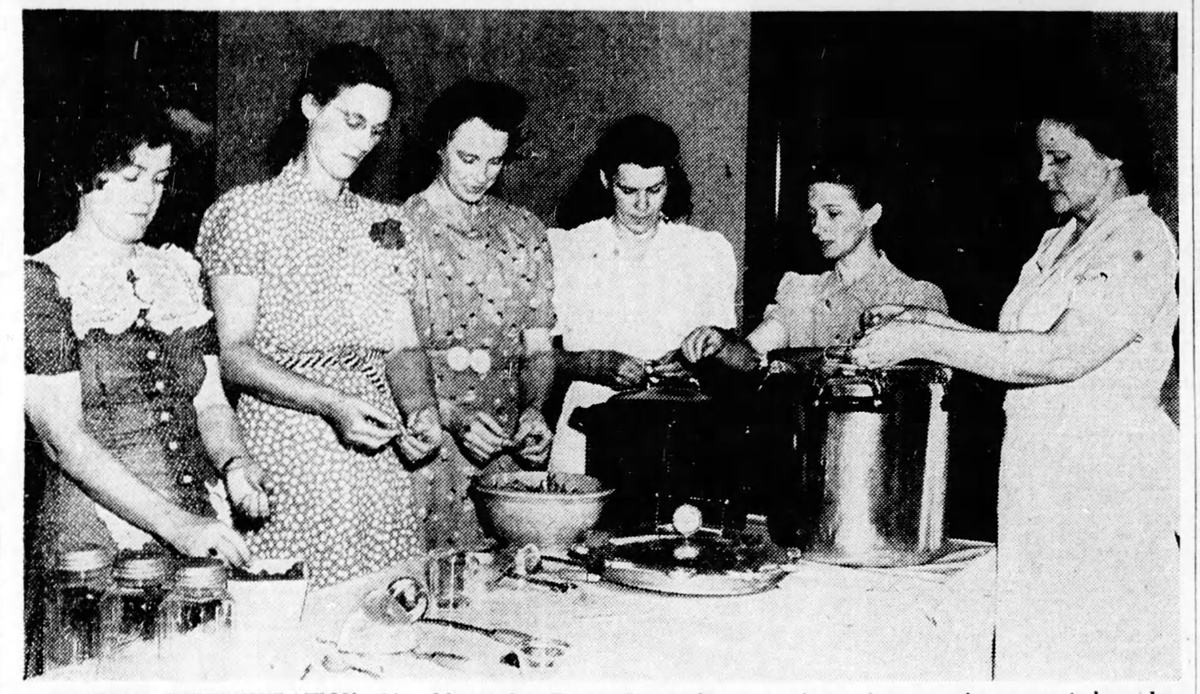 Home Demonstration Agent Mamie Sue Evans hosts a food canning class for a group of women in 1941. 