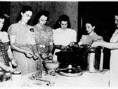Home Demonstration Agent Mamie Sue Evans hosts a food canning class for a group of women in 1941.