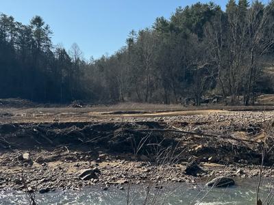 A farm field showing eroded streambanks and flood deposits.