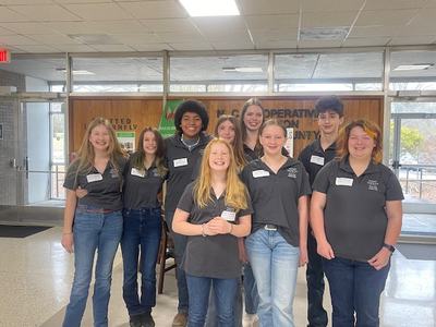 A group of 4-H kids pose together at a horse bowl competition. 