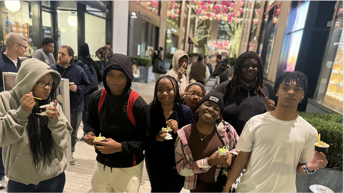 Teens eat ice cream together.
