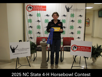 Person holding blue ribbon and envelope at 2025 NC State 4-H Horsebowl Contest