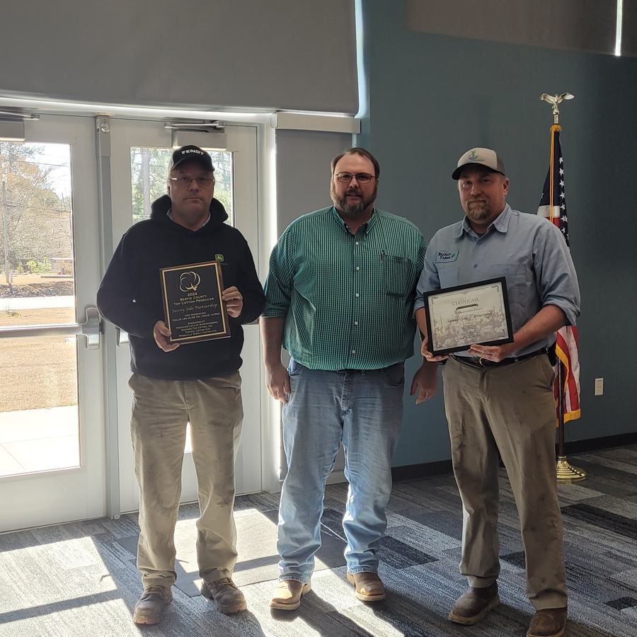 Three men pose with awards.