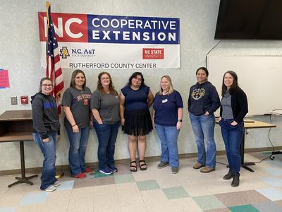 Eight people standing under banner "NC Cooperative Extension Rutherford County Center"