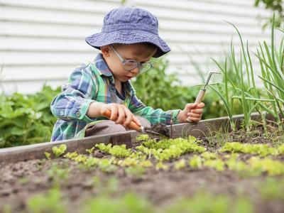 child planting in a garden 