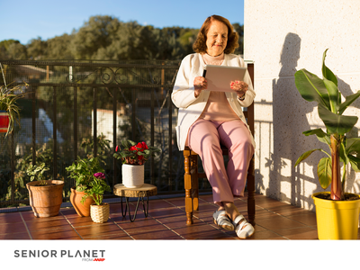 Older woman on balcony using tablet among potted plants; label "SENIOR PLANET from AARP"