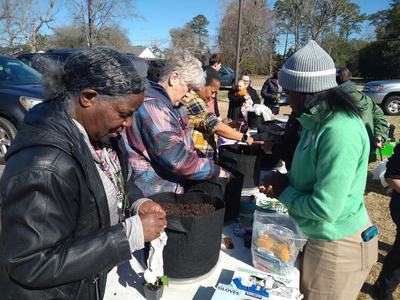 People picking up buckets to grow vegetables