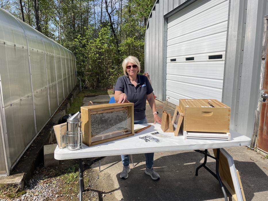 A woman shows off a bee box.