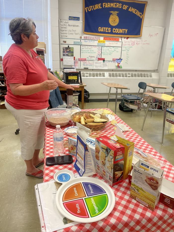 A woman discusses grains on a plate.