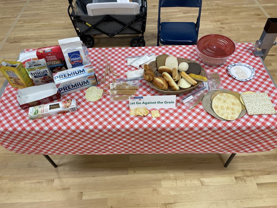 Products on a table that contain grains and a sign that says "Let Go Against the Grain"
