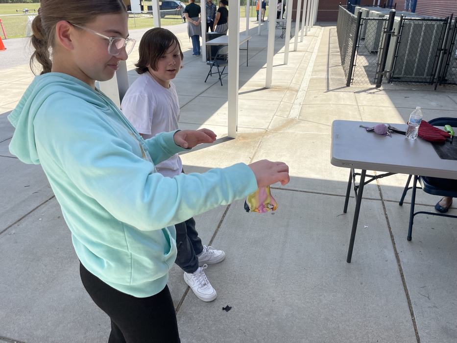 A girl makes a face while picking up an item.