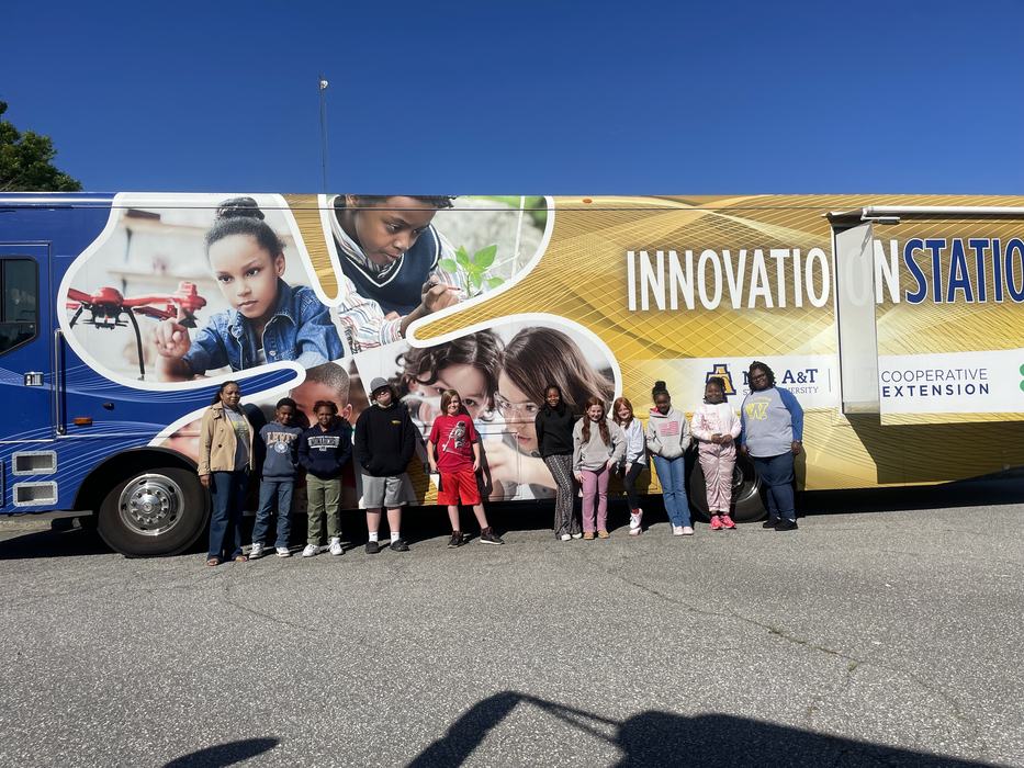 Children pose outside the Innovation Station bus.