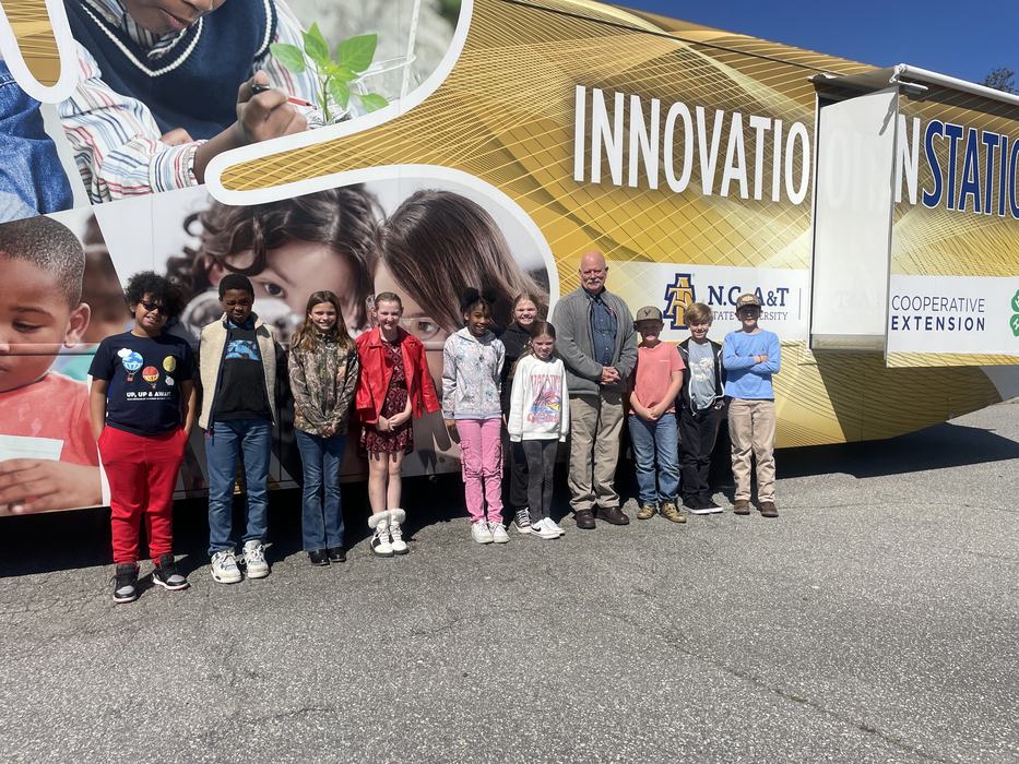 Children and instructors stand outside the Innovation Station.