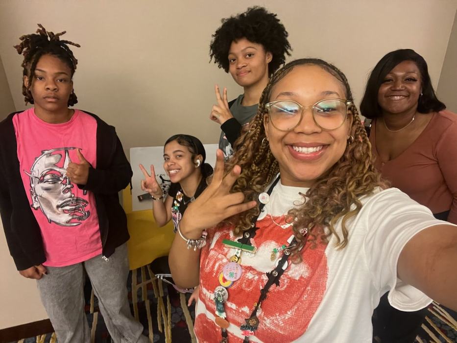4-Her's pose together in a room where they were working on content together.
