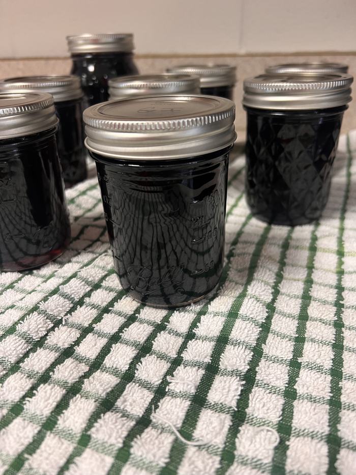 Jars of jelly resting on a towel.