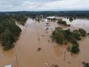 Aerial view of flooded road with submerged buildings, trees, cars, and utility poles