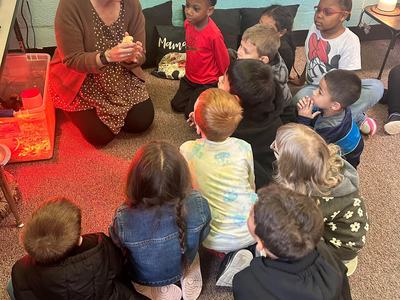 woman holding a chick while her students look on