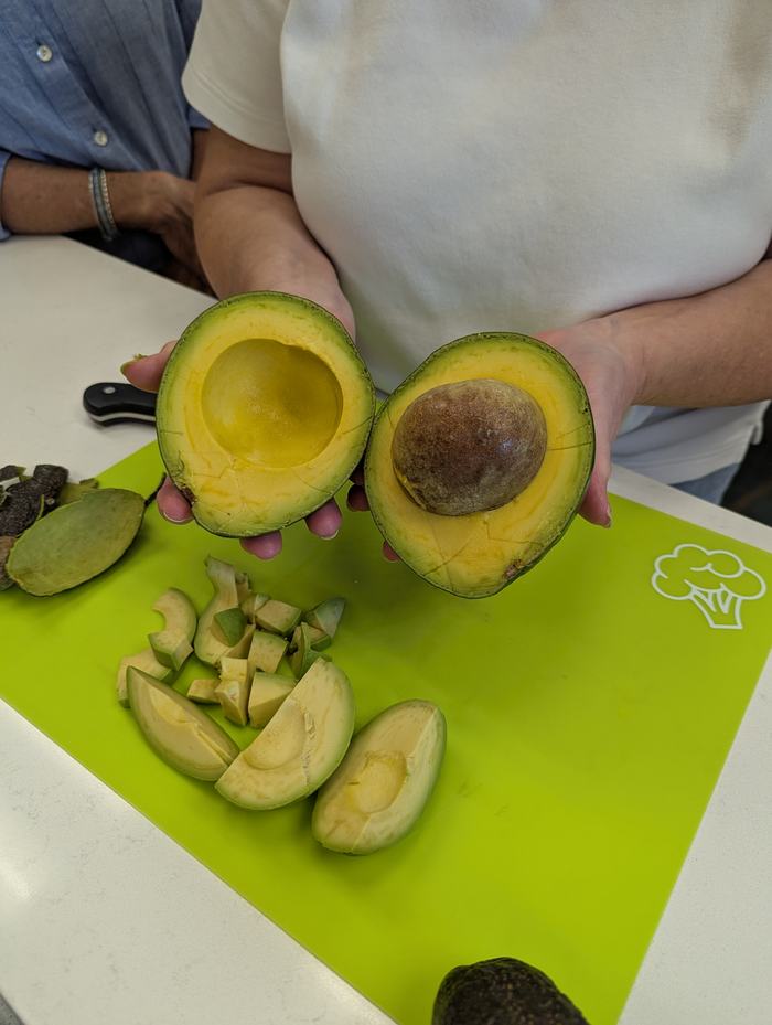 An open avocado with the pit still inside.