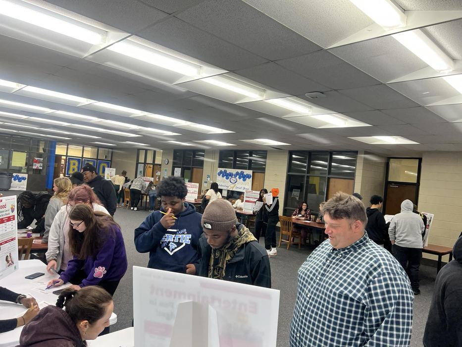 Students move from booth to booth, simulating life events.