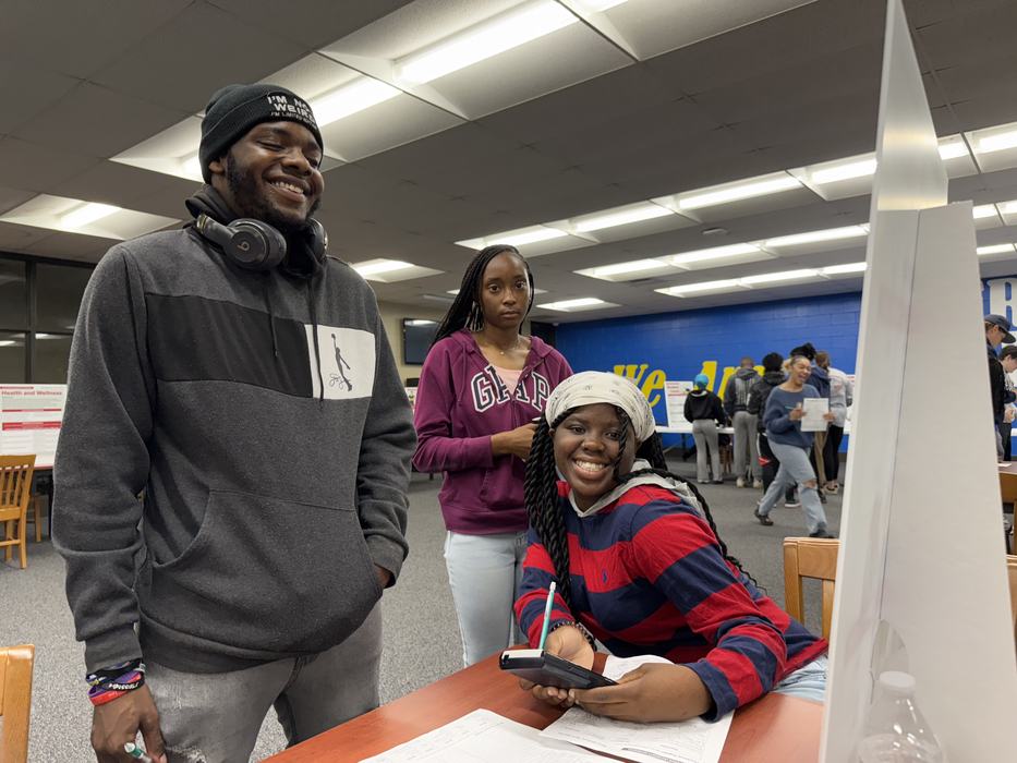Students smile while working on budgets together.