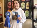 Photo of a girl holding two blue ribbons & horse photo