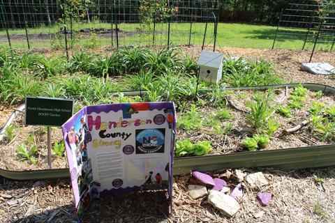 Raised garden bed with sign "North Henderson High School BOOST Garden" and board "Henderson County Strong"