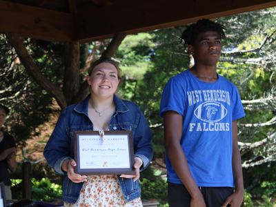 Two students hold an award they have recieved.