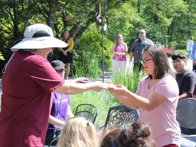 A woman hands out an award to another woman.