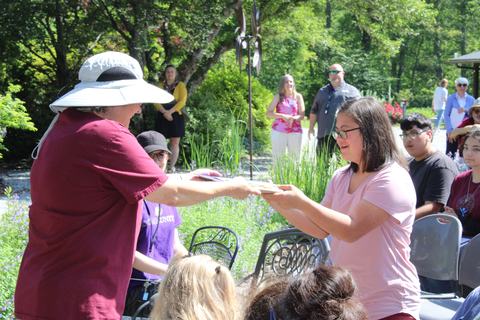 A woman hands out an award to another woman.
