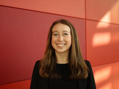 Young woman smiling against a red paneled wall